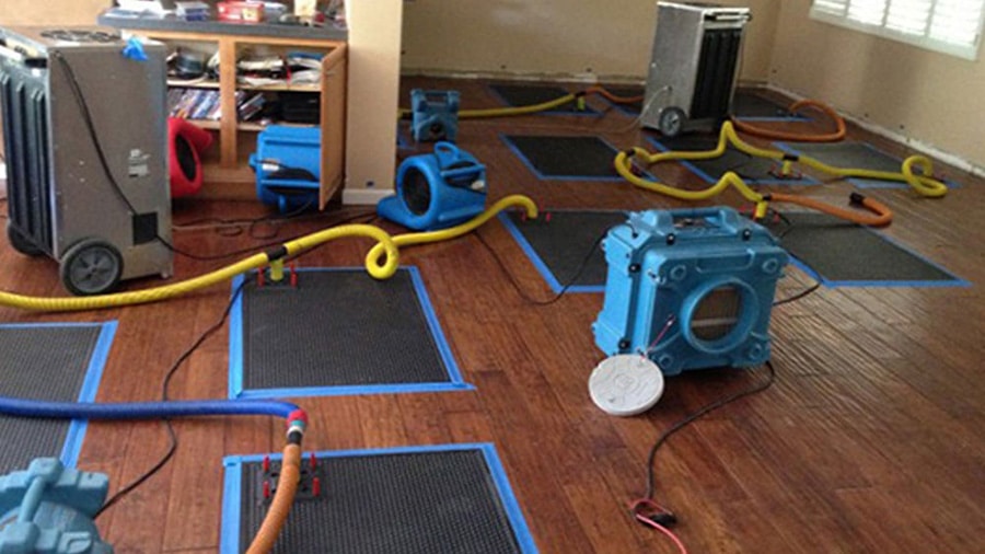 A certified technician from Omaha Water Restoration sets up four turbo drying fans, two air scrubbers, and two dehumidifiers in a home in Omaha, NE, requiring emergency water mitigation.