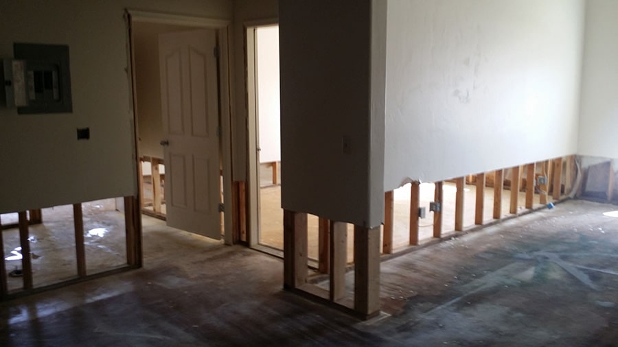 A basement in Bellevue, NE damaged by water has 24 inches of drywall and flooring removed leaving the wood framing exposed.